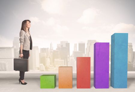 Business person climbing up on colourful chart pillars concept on city background