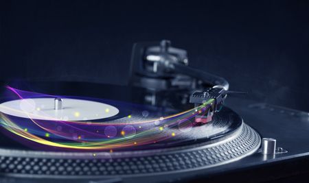 Turntable playing vinyl with glowing abstract lines concept on background