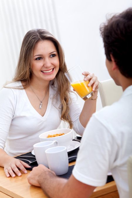 Beautiful couple eating their breakfast at home