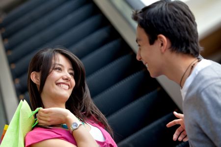 Couple talking at a shopping center and smiling