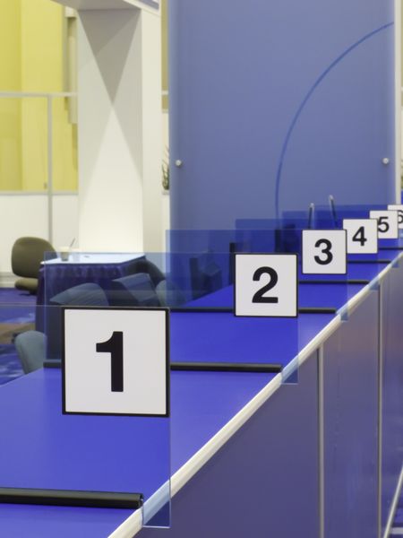 Numbered stations along blue registration counter in convention hall