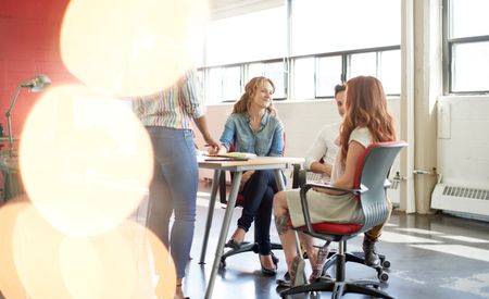 Unposed group of creative business people in an open concept office brainstorming their next project.