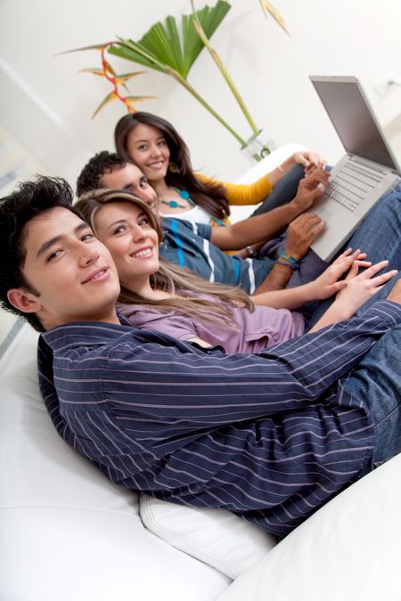 Group of young people sitting on the sofa with a laptop