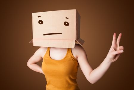 Young girl standing and gesturing with a cardboard box on her head with straight face