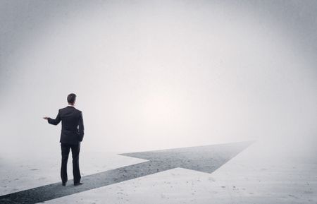 professional-businessman-thinking-standing-black-arrow-424183816 A professional businessman thinking while standing on a black arrow pointing forward in grey space concept