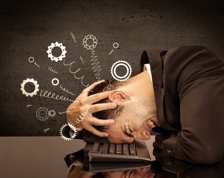 Falling apart illustration concept with cranks, cog wheels springing from a fed up and tired businessman's head resting on laptop keyboard