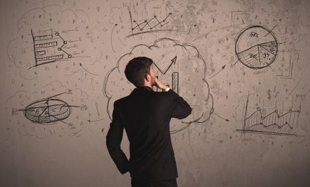 Businessman drawing a business project on a wall