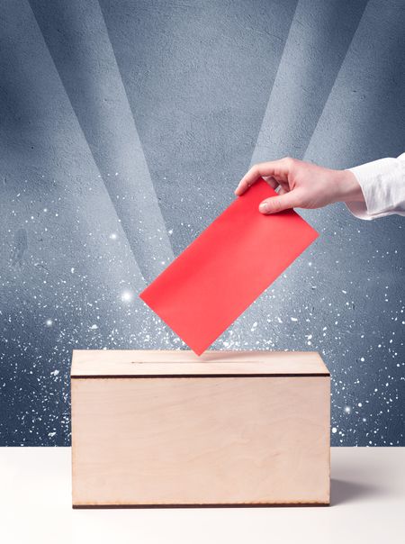 Ballot box with person casting vote on sparkling background