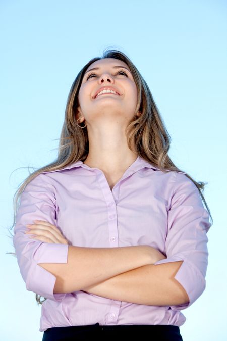 Beautiful business woman looking up with arms crossed