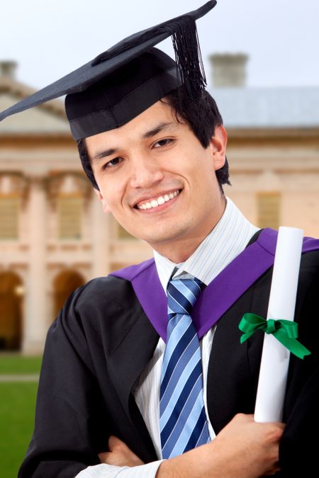 Graduation man portrait smiling and looking happy outdoors