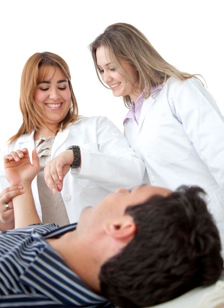 Beautiful female doctors with a patient isolated on white