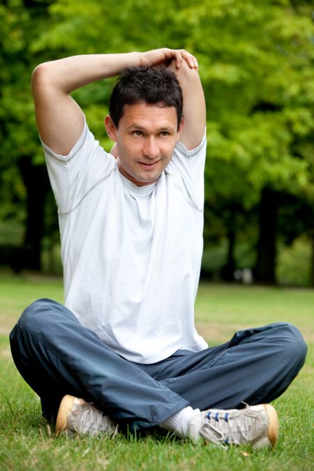 Man doing stretching exercise for her arms and back at the park