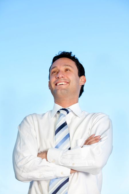 Business man with arms crossed over a blue sky