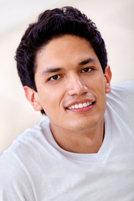 Casual man portrait looking happy and confident indoors