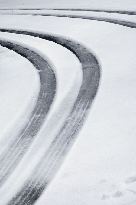 Tire tracks on snowy suburban driveway