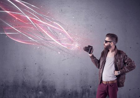 A stylish funny hipster person holding a vintage camera and taking photographs illustrated with glowing red, white lines concept