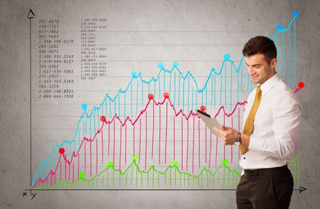A confident young businessman standing in front of a a chart with graphs and numberswhile talking on the phone concept