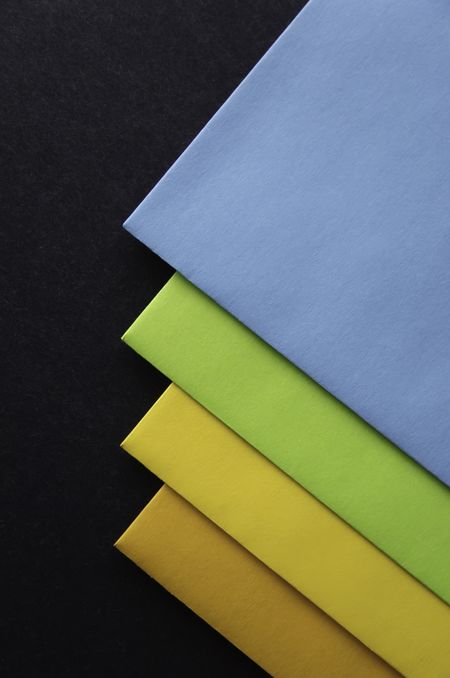 Four colored envelopes on black cardboard