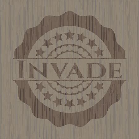 Invade badge with wooden background