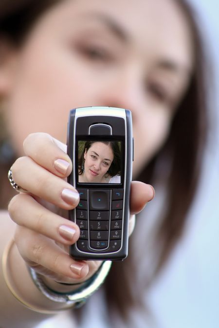 beautiful girl showing her black mobile phone