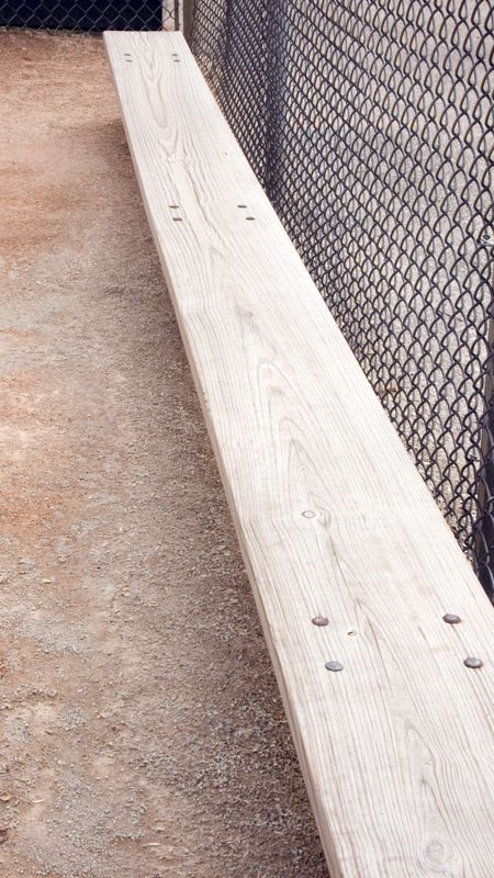 Player's view of vacant bench in dugout of baseball field