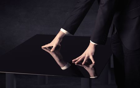 Close up of a hand touching smart table with copy space on black background