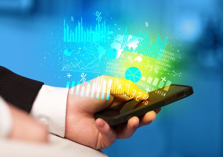 Hand holding smartphone with business diagrams on it