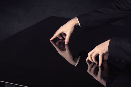 Close up of a hand touching smart table with copy space on black background