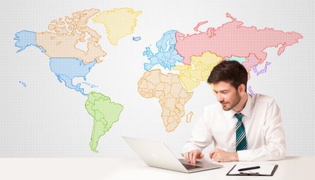 Businessman sitting at white table with colorful world map background