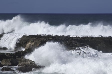 Surf pounds volcanic rock in Hawaii