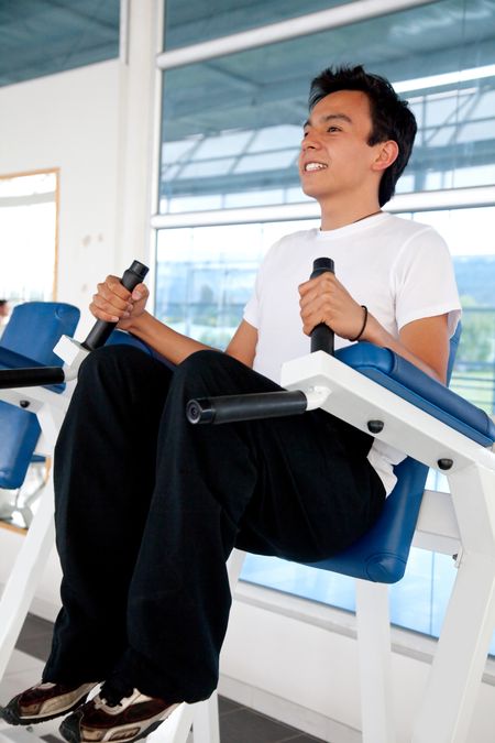 Young man exercising at the gym and smiling