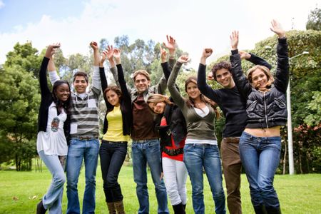 Excited group of people smiling with their arms up