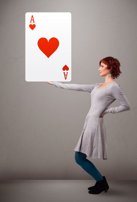 Beautiful young woman holding red heart ace