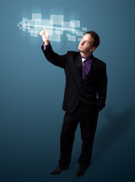 Businessman pressing high tech type of modern buttons on a virtual background