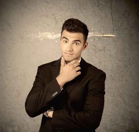 An elegant handsome business guy standing in front of wall with a bullet going through his head, making facial expressions concept