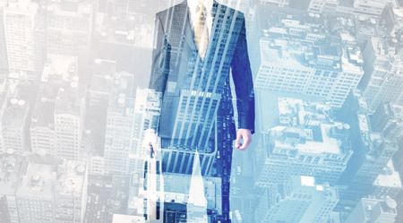 Business person standing with blue cityscape in the background