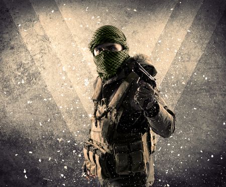 Portrait of a dangerous masked armed soldier with grungy light background