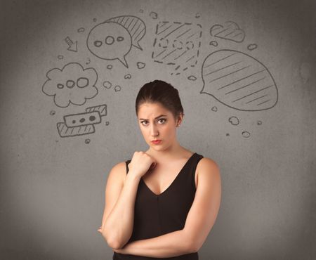 A cute female student making funny expressions with thoughts in her head illustrated by drawn chat bubbles on the urban wall background concept.