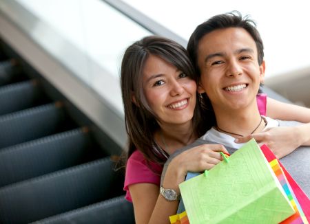 Happy couple at a shopping center with bags