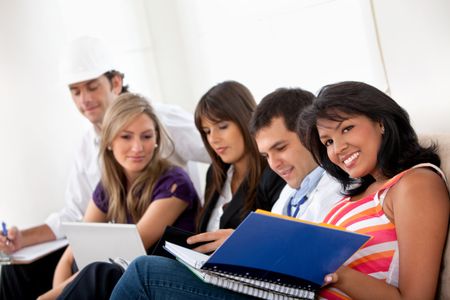 Group of happy people with different professions sitting on a sofa