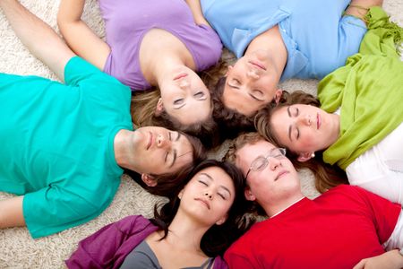 Group of friends together lying on the floor with eyes closed