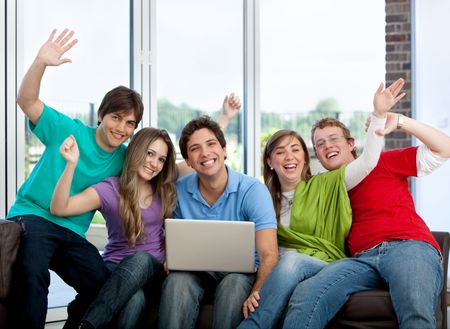 Excited group of friends together browsing on the computer inside