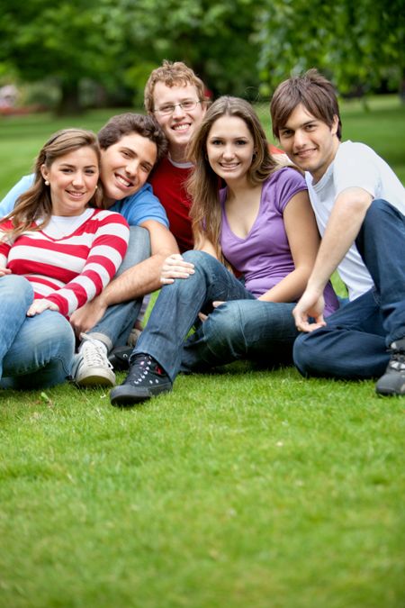 Happy group of friends sitting outdoors and smiling