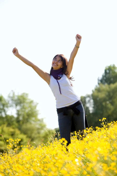 Excited woman outdoors with her arms up