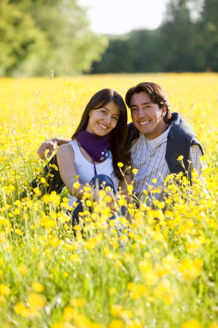 Beautiful couple outdoors in a meadow smiling
