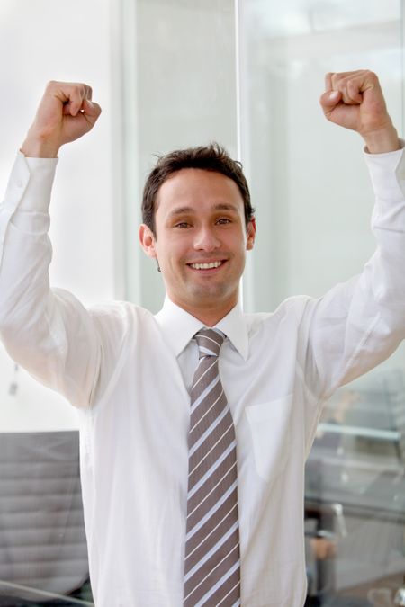 Successful young business man with arms up