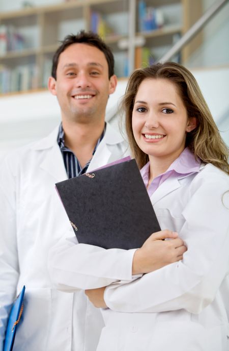 Couple of young doctors smiling at the hospital