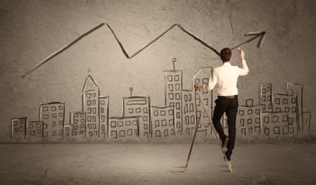 A man in elegant suit standing on a small ladder and drawing a line on brown wall background with buildings