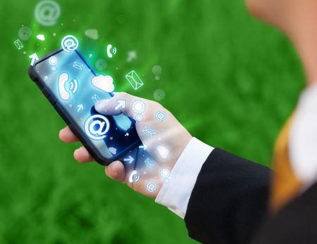 Business man holding smart phone with media icons concept on background