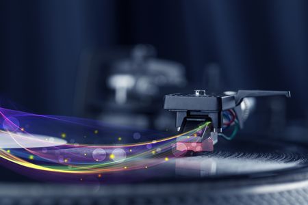 Turntable playing vinyl with glowing abstract lines concept on background
